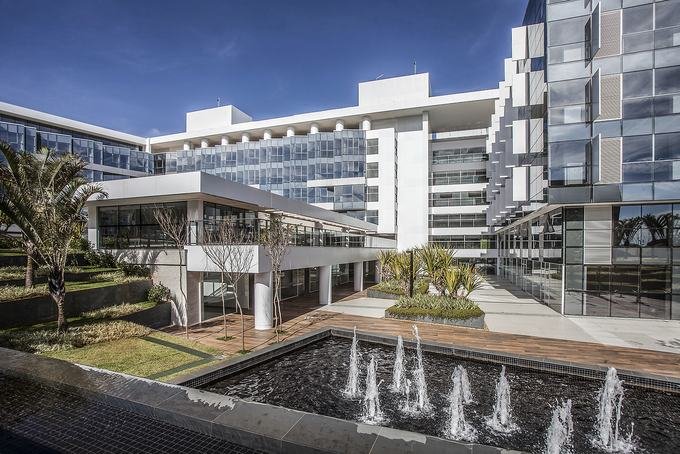 Pátio central do campus com espelho d'água e passarelas